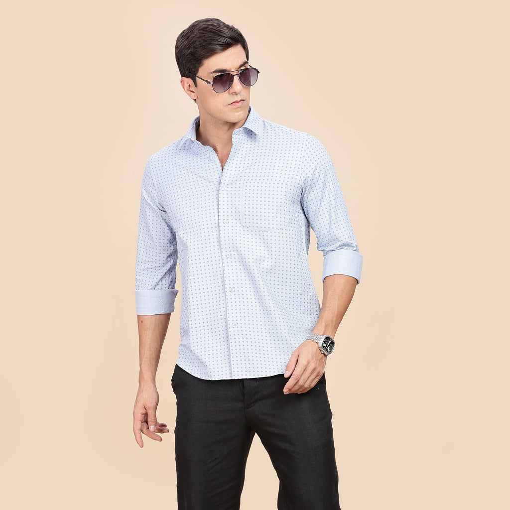 Man wearing a light blue checkered shirt and black pants on a beige background