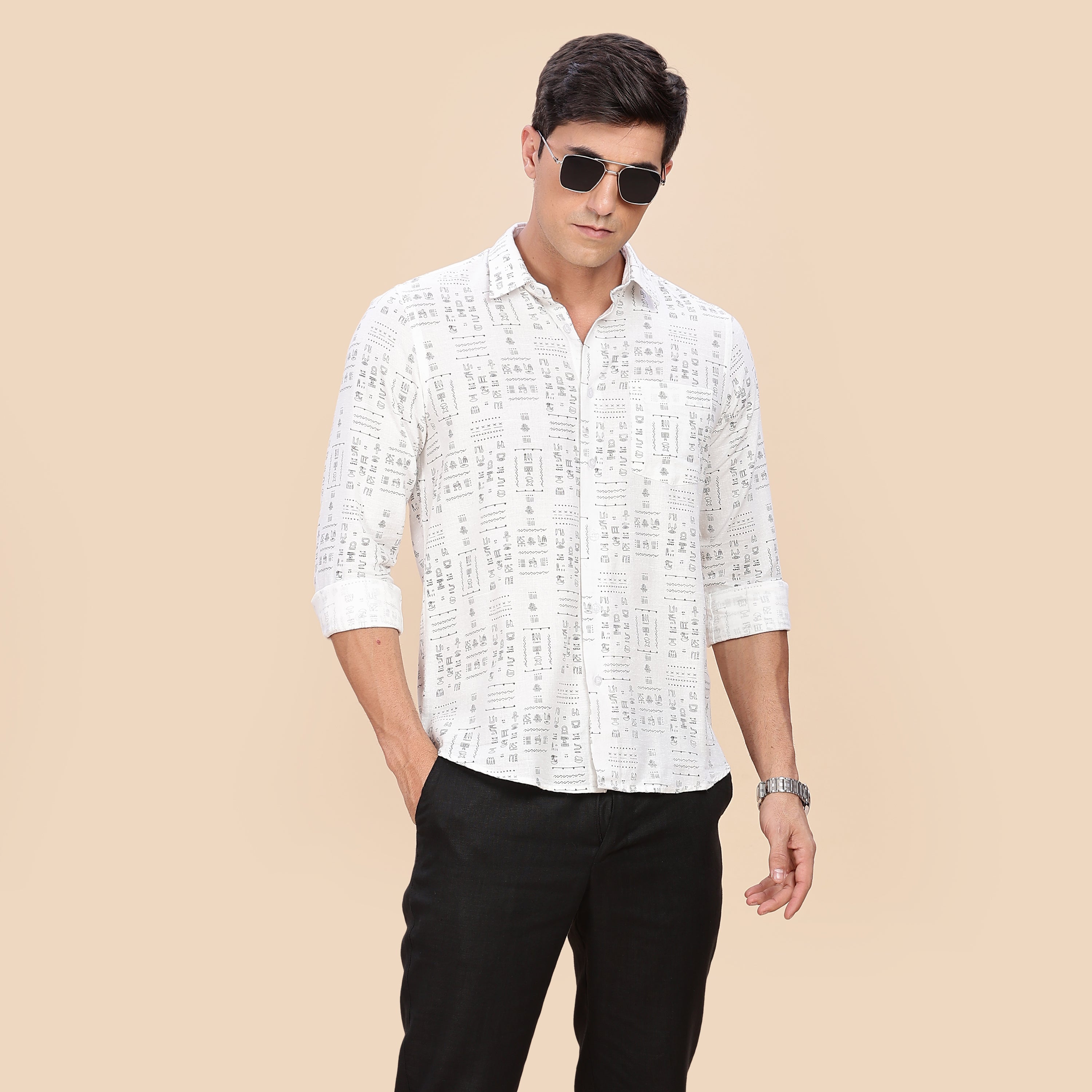 Man wearing a white patterned shirt and black pants on a beige background